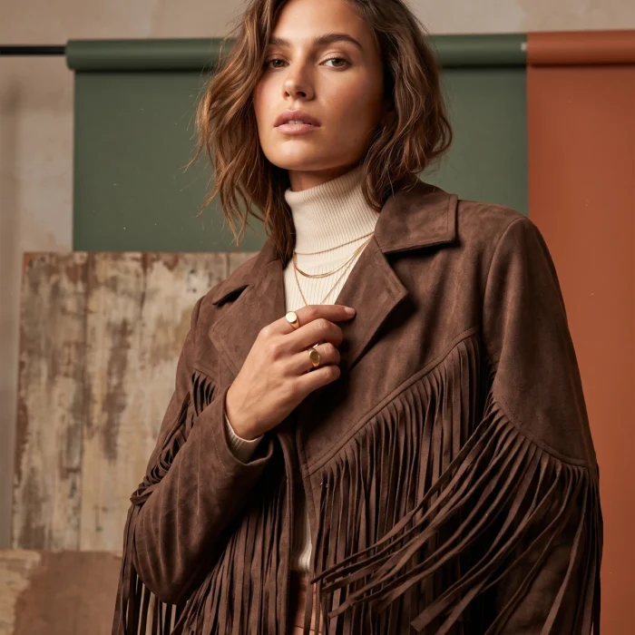 Modelo con chaqueta de flecos marrón y jersey cuello alto, look street style