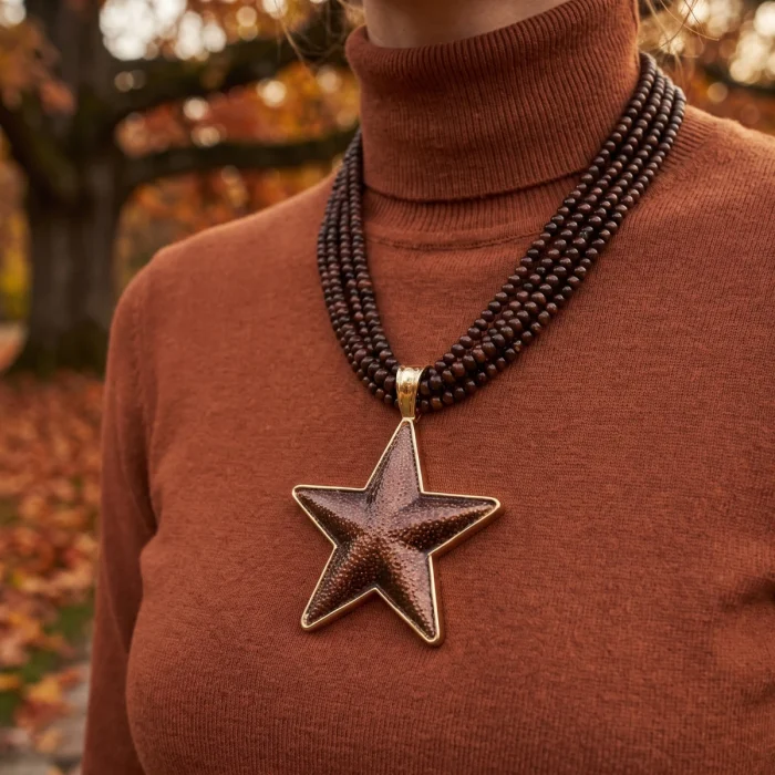 Detalle del colgante de estrella dorado y cuentas multivuelta marrón del collar boho chic Kloreys